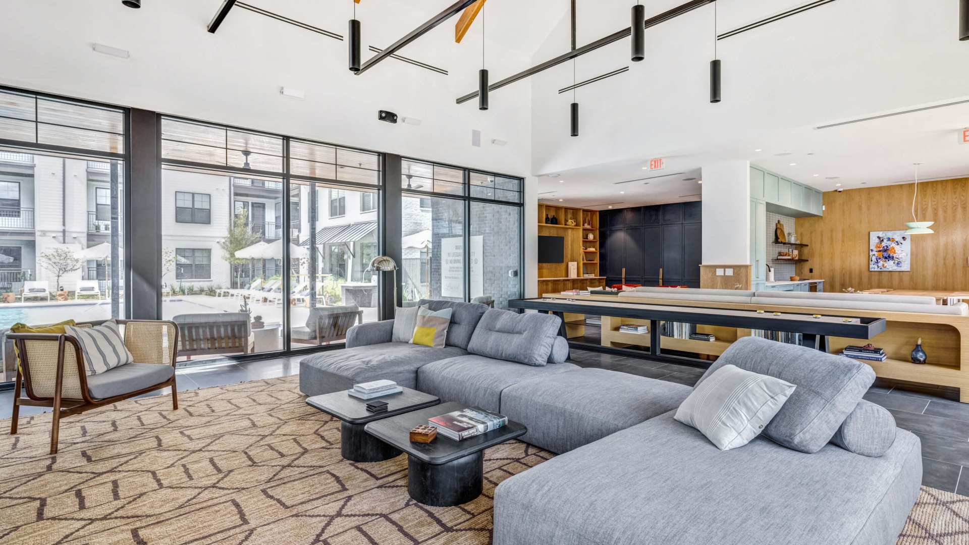 Gameroom with lounge seating, shuffle board and poolside view